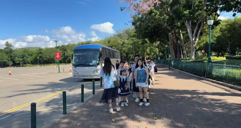 綠惜香港暢遊迪士尼2026，參加者到埗後在旅遊巴旁步行